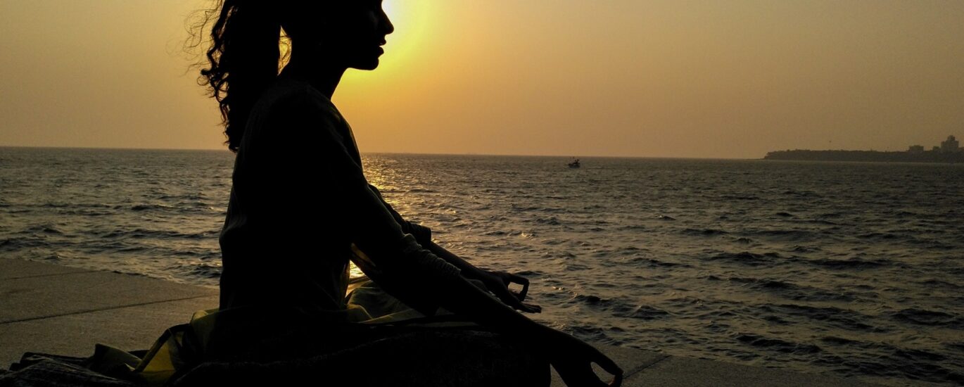 Woman meditating by the ocean