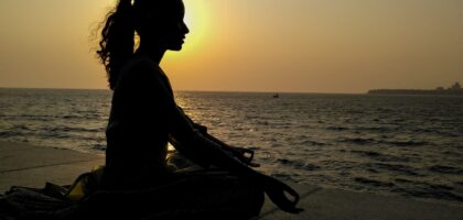 Woman meditating by the ocean